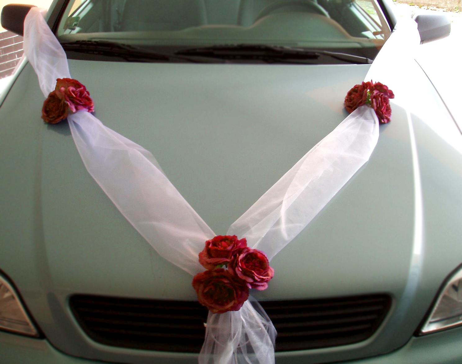 Svadobná výzdoba na auto s bielou stuhou a červenými ružičkami A 047